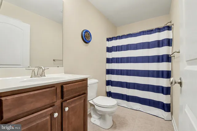 a bathroom with a sink a toilet a mirror and shower curtain