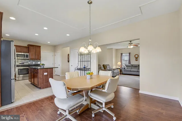 a dining room with furniture a chandelier and wooden floor