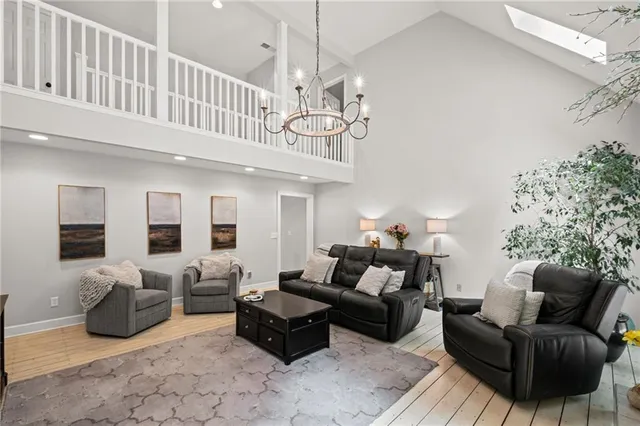 a living room with furniture a chandelier and a flat screen tv