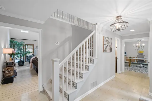 a view of staircase with furniture and a chandelier