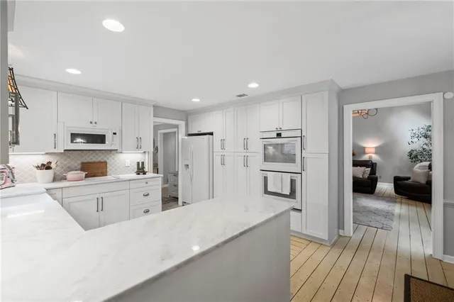 a kitchen with refrigerator cabinets and wooden floor