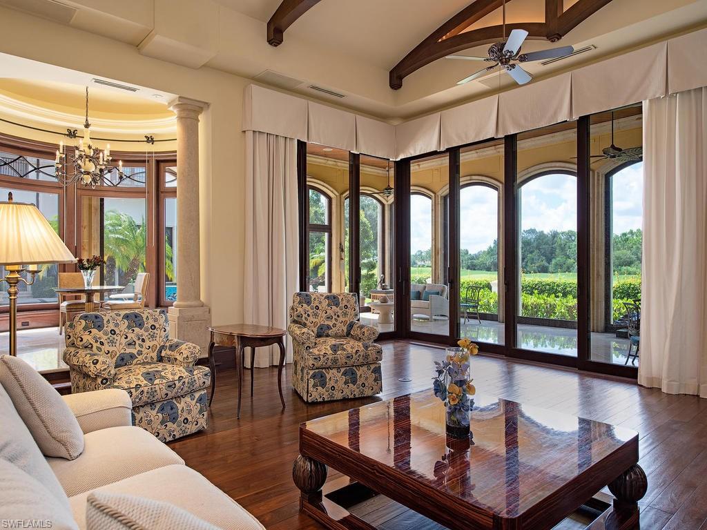 9766 Bent Grass Bend Naples, FL 34108 - Photo 13 of 35 a living room with furniture large windows and wooden floor