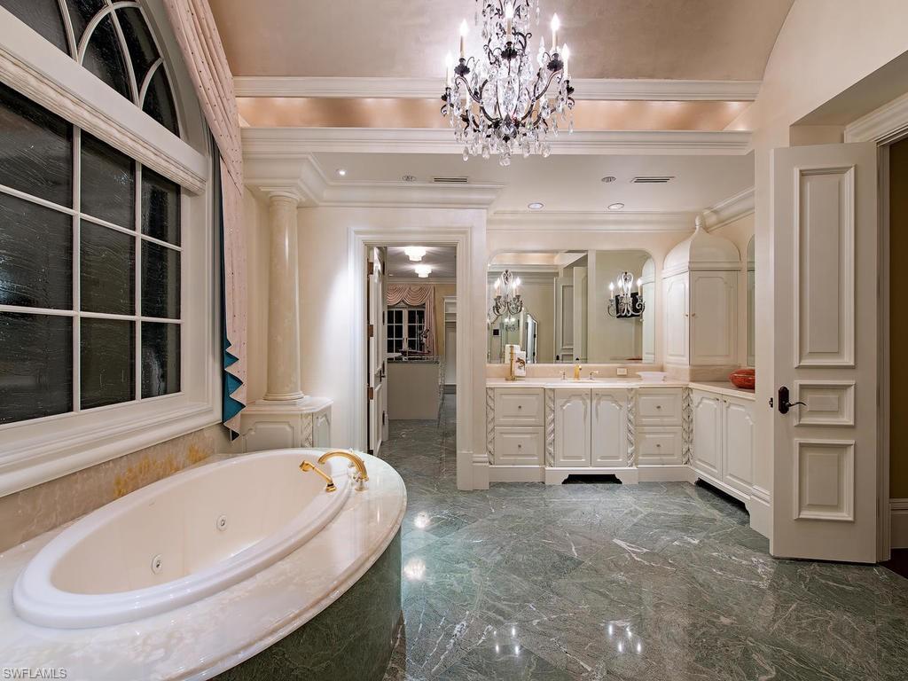 9766 Bent Grass Bend Naples, FL 34108 - Photo 22 of 35 a bathroom with a tub sink and glass door