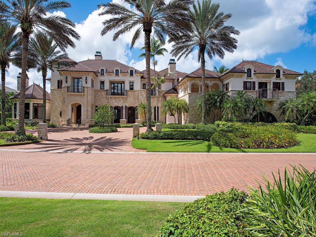 9766 Bent Grass Bend Naples, FL 34108 - Photo 33 of 35 a front view of a house with a garden and palm trees
