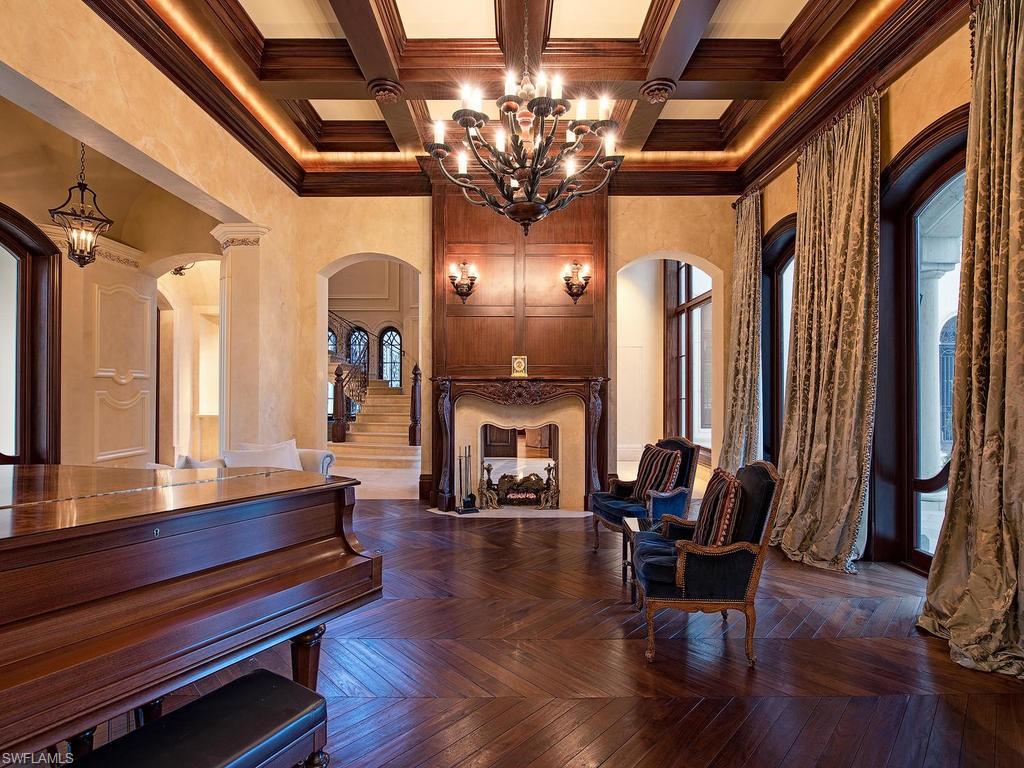 9766 Bent Grass Bend Naples, FL 34108 - Photo 6 of 35 a living room with fireplace furniture and a chandelier