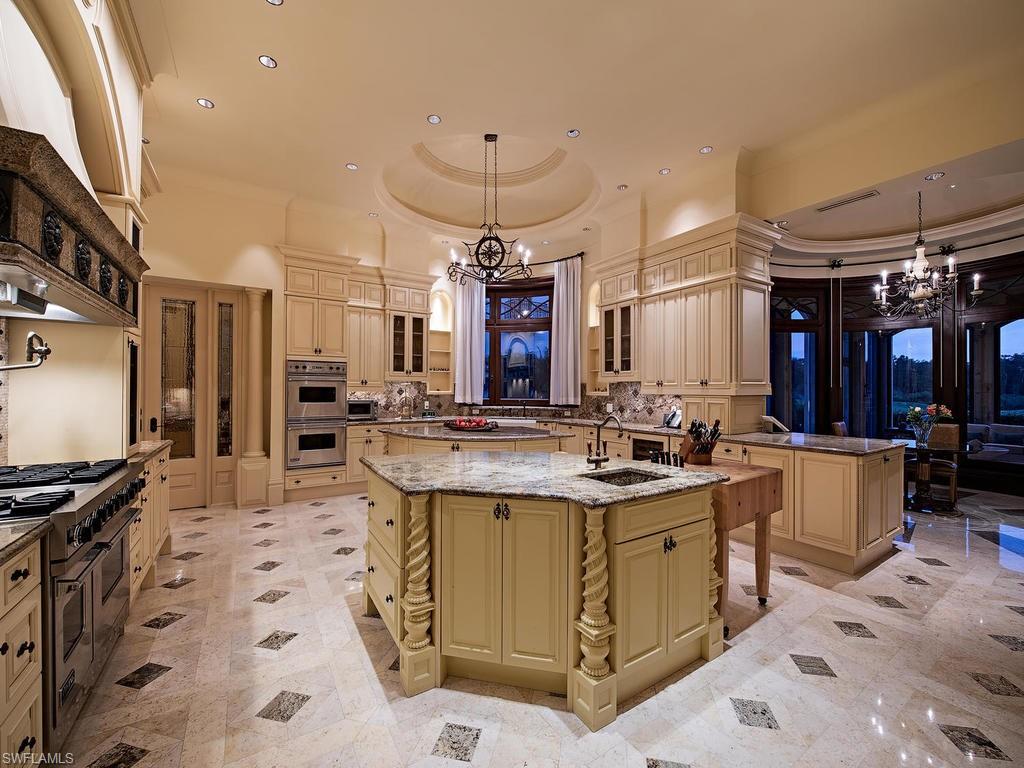 9766 Bent Grass Bend Naples, FL 34108 - Photo 8 of 35 a view of a kitchen with kitchen island stainless steel appliances a stove a sink a center island and furniture