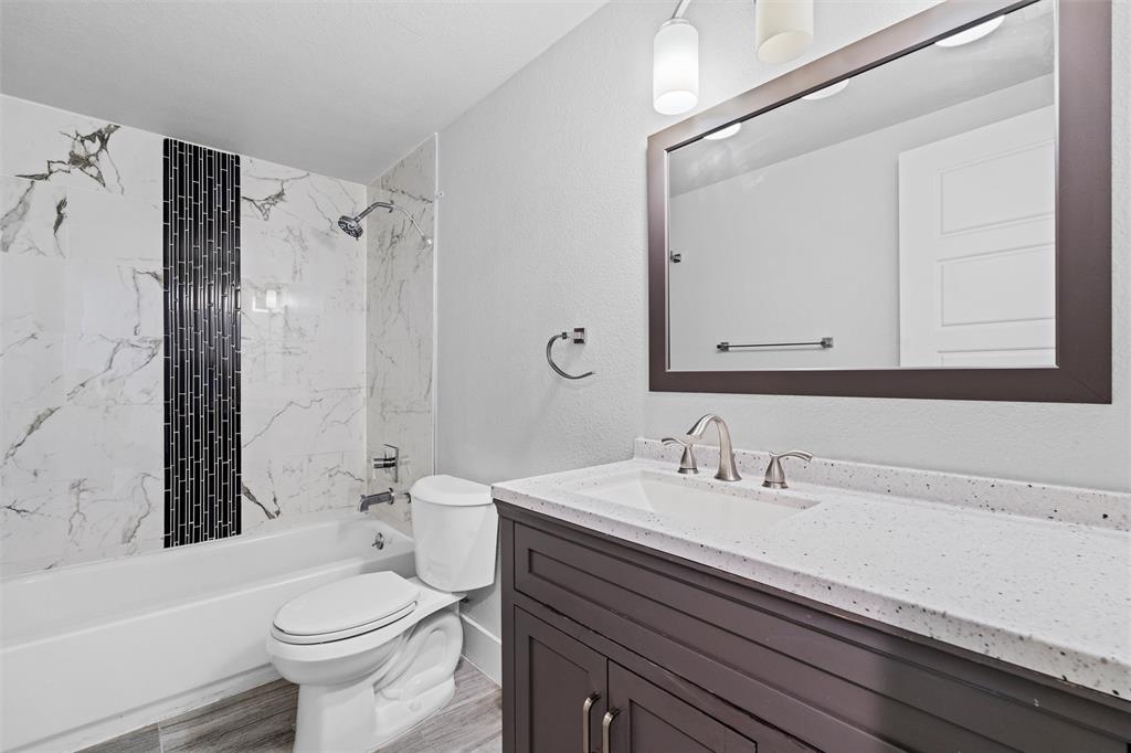 3514 Larry Street Rowlett, TX 75088 - Photo 17 of 27 a bathroom with a sink a toilet a mirror and shower