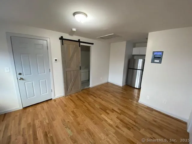 a kitchen with stainless steel appliances granite countertop a refrigerator a stove a sink and a hard wood floors