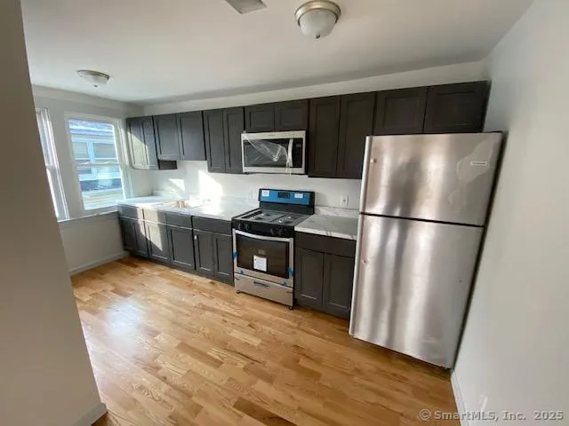 a kitchen with stainless steel appliances a refrigerator stove microwave and sink