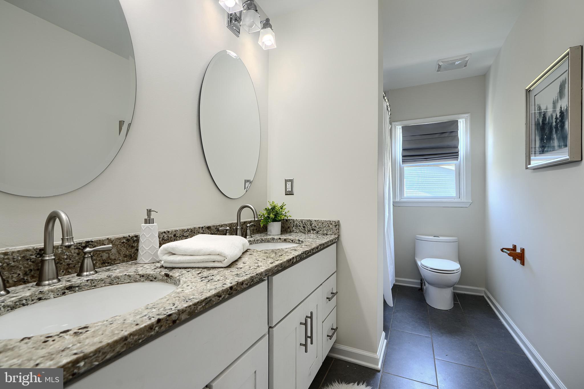 2903 Sparrows Point Road Sparrows Point, MD 21219 - Photo 29 of 57 a bathroom with a granite countertop sink a toilet and a mirror