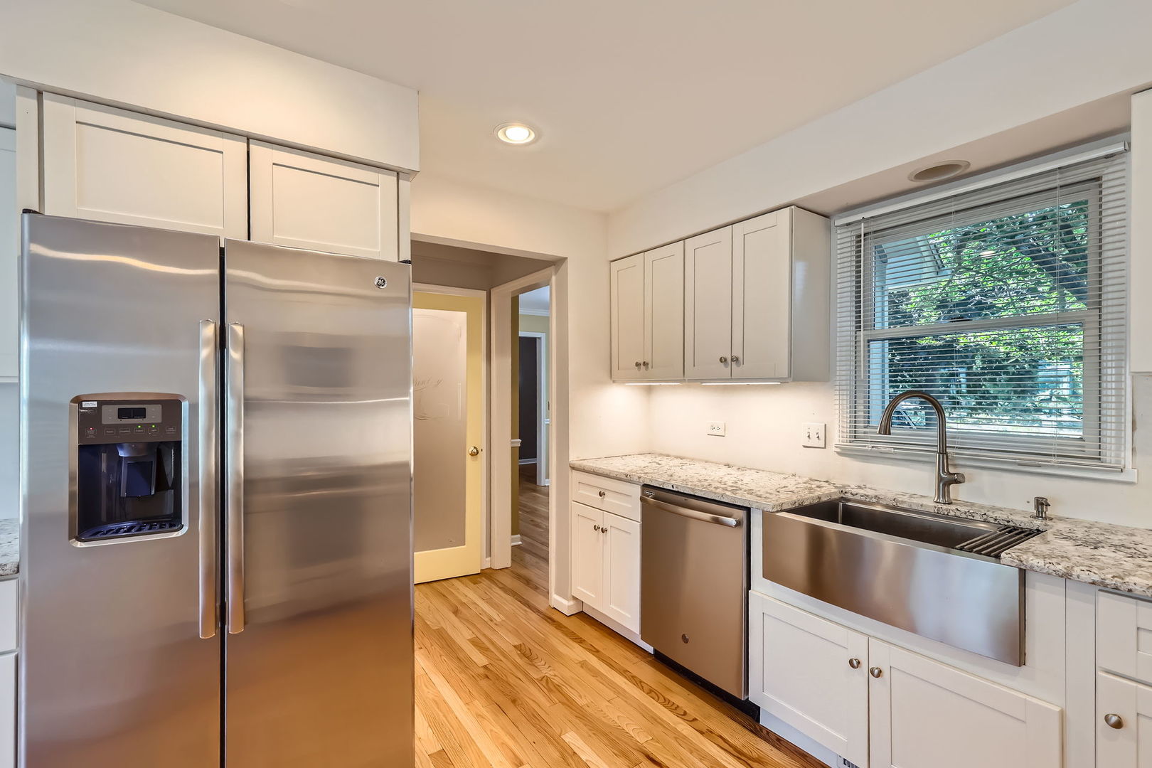 201 South Wulff Street Cary, IL 60013 - Photo 4 of 31 a kitchen with a sink cabinets stainless steel appliances and a window
