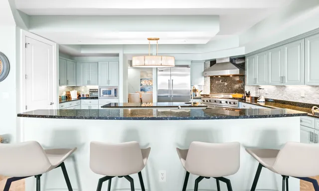 a kitchen with stainless steel appliances kitchen island granite countertop a stove a sink and a refrigerator