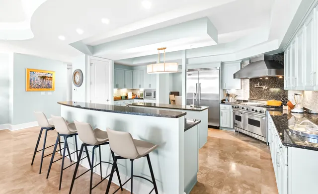 a kitchen with stainless steel appliances granite countertop a sink a stove and a refrigerator