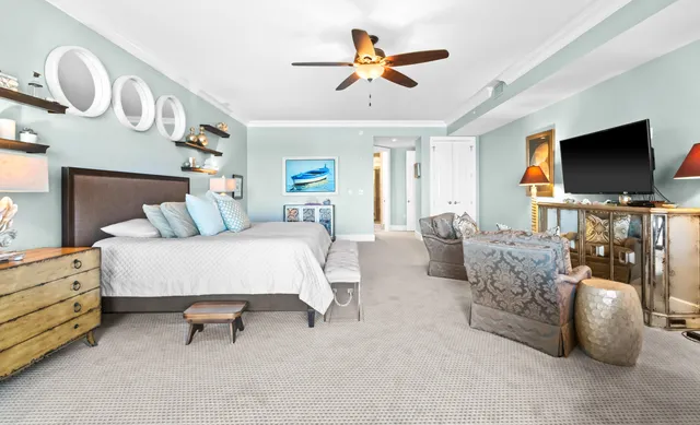 a bedroom with a bed and a lamp on dresser next to a window