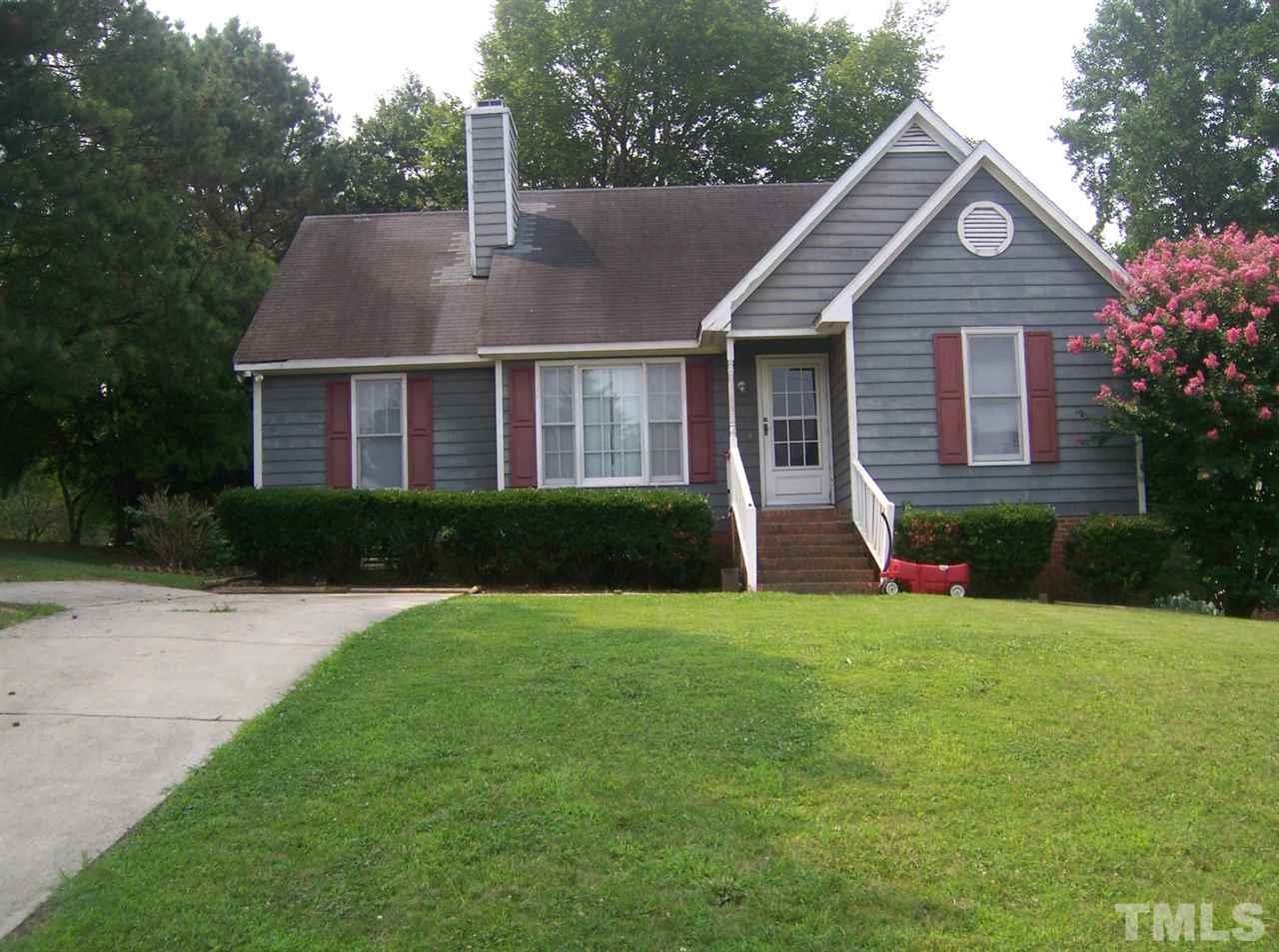 a front view of a house with a yard and trees