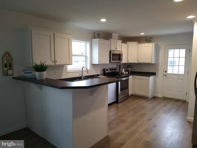 a kitchen with sink a microwave and cabinets