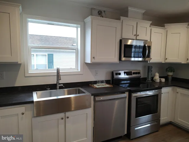 a kitchen with granite countertop white cabinets and a sink