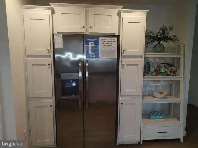 a kitchen with a refrigerator and wooden floor