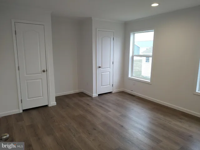 an empty room with wooden floor and window