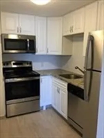 a kitchen with granite countertop a stove and a microwave