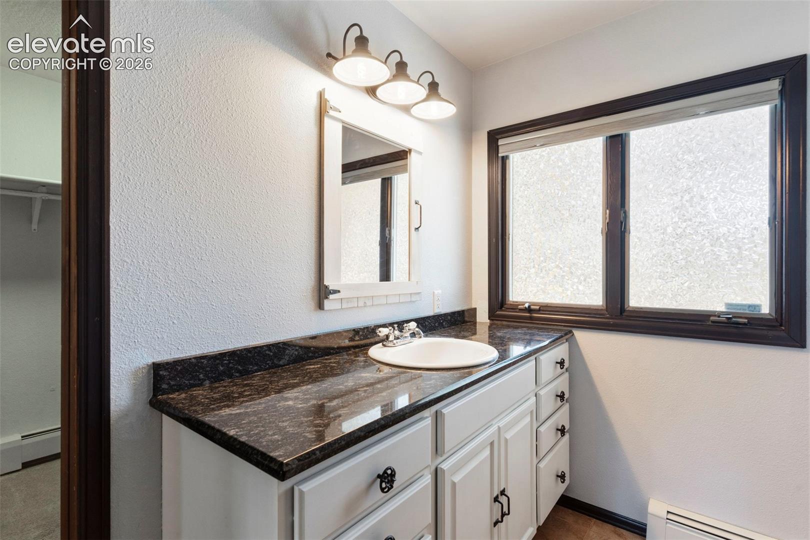 10765 Falling Star Road Fountain, CO 80817 - Photo 11 of 27 Bathroom vanity with granite-style countertop, integrated sink, and white cabinetry
