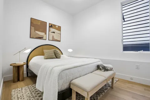 a bedroom with a bed and a painting on the wall