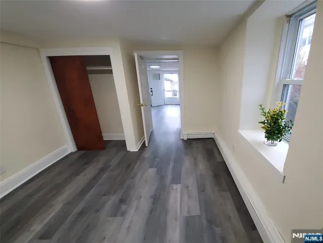 a kitchen with stainless steel appliances granite countertop wooden floors wooden cabinets a sink and a window