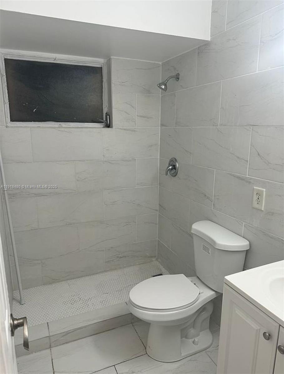 9453 Southwest 76th Street, Unit S7 Miami, FL 33173 - Photo 4 of 12 a bathroom with a toilet a sink a shower and mirror