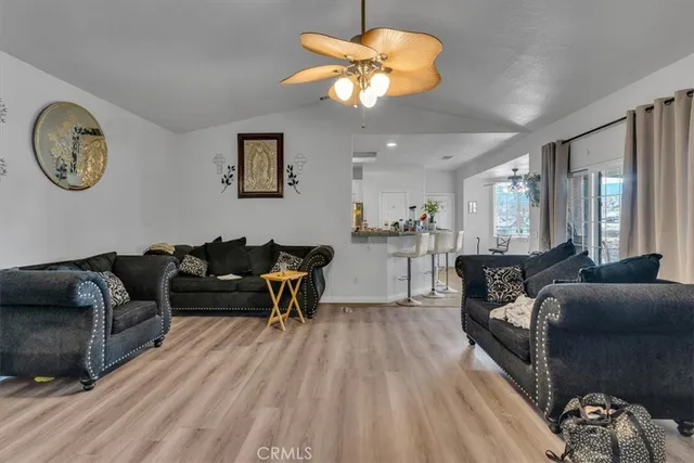 a living room with furniture a clock on wall and a large window