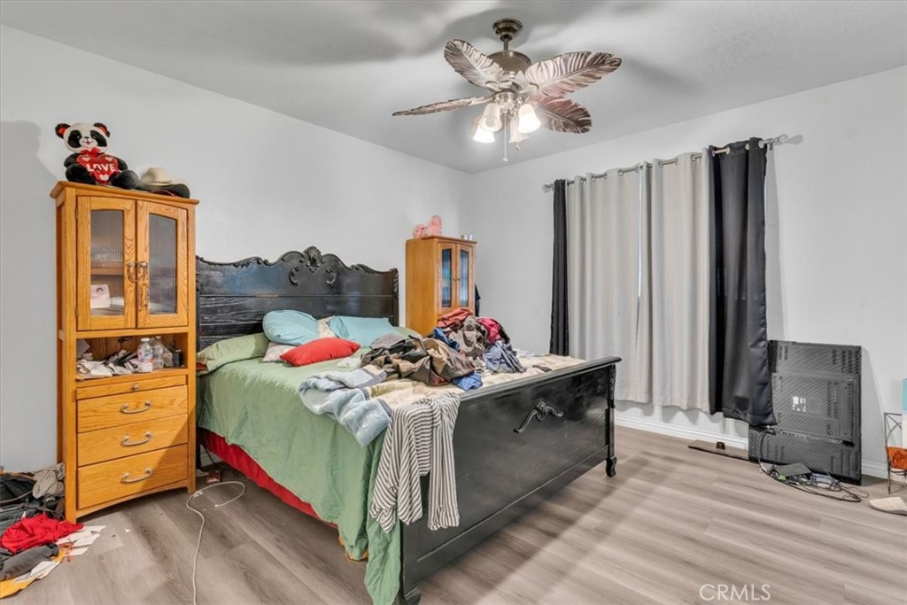 12008 Sierra Vista Road Phelan, CA 92371 - Photo 15 of 29 a bed room with a bed and a chandelier
