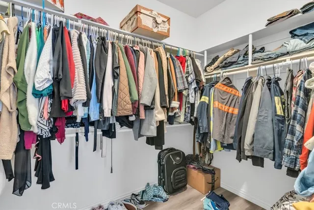 a view of walk in closet with clothes and shoes