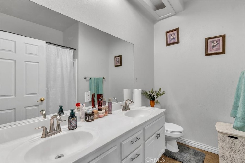 12008 Sierra Vista Road Phelan, CA 92371 - Photo 19 of 29 a bathroom with a sink toilet and shower