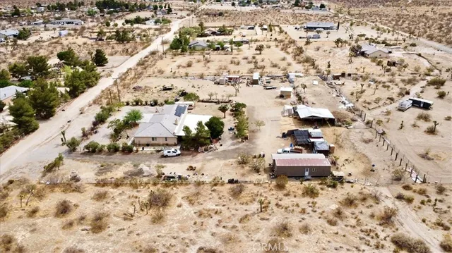 an aerial view of a house with a yard and large trees