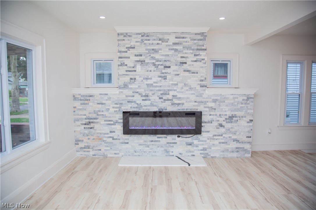 3554 Ludgate Road Shaker Heights, OH 44120 - Photo 8 of 50 Stacked stone fireplace with an electric insert, wood-finish flooring, and recessed lighting