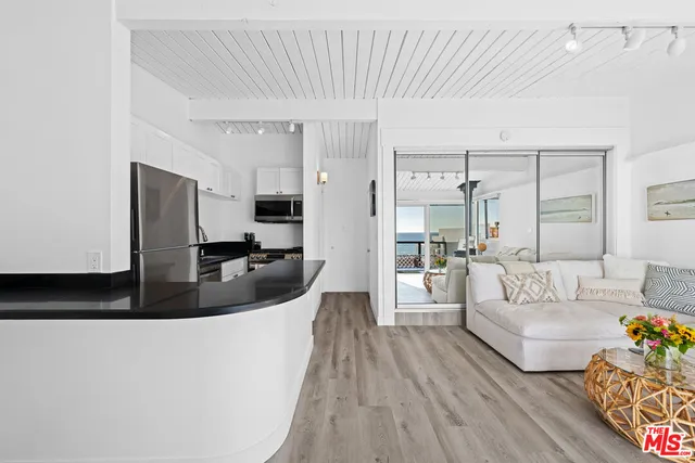 a kitchen with granite countertop a refrigerator a stove a microwave and cabinets