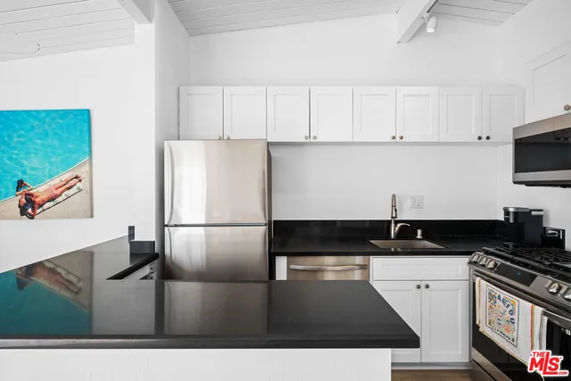 a kitchen with stainless steel appliances a refrigerator a stove a microwave and cabinets