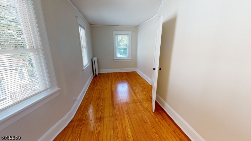 40-42 Dunnell Road Maplewood, NJ 07040 - Photo 16 of 18 a view of a hallway with wooden floor and a bathroom