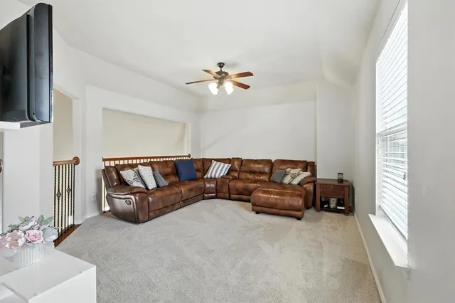 a living room with furniture a flat screen tv and a window
