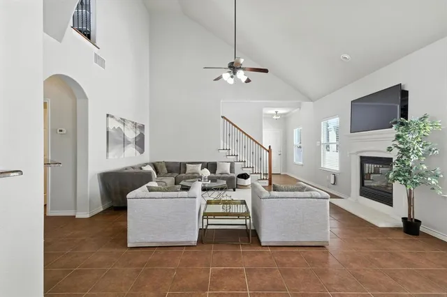a living room with furniture a fireplace and a potted plant