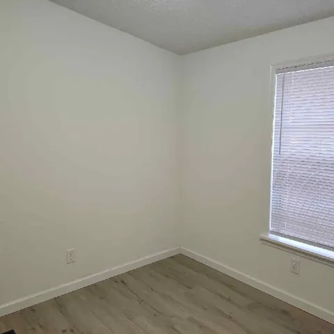 a view of a small space with wooden floor and a window