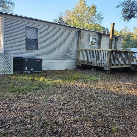 a view of a house with a yard and wooden fence