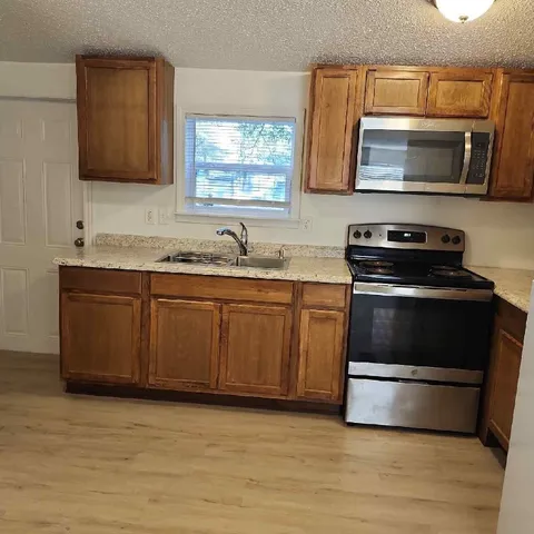 a kitchen with a sink stove and microwave