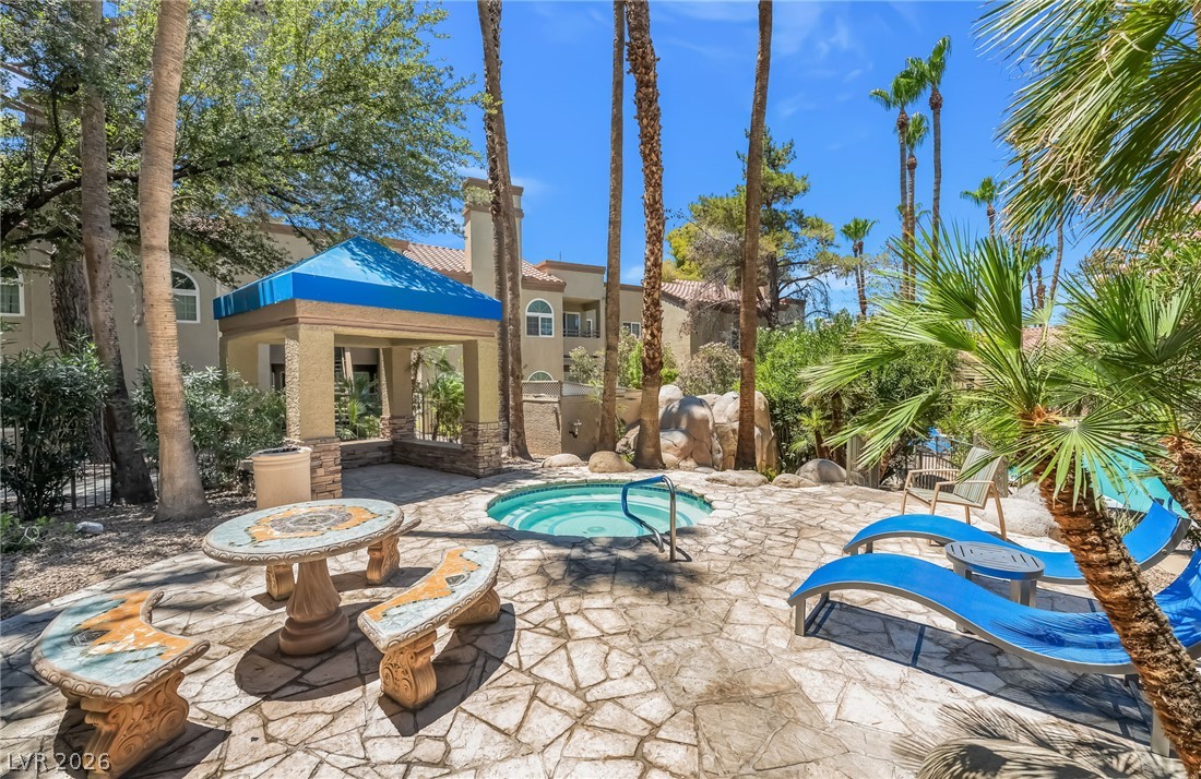 3145 East Flamingo Road, Unit 1092 Las Vegas, NV 89121 - Photo 27 of 33 An inviting outdoor spa with stone patio and lush palm trees awaits.