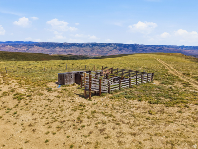 10780 Ford Ridge Road Helper, UT 84526 - Photo 15 of 38 Wooden corral with an adjacent shed structure, set within a vast open landscape