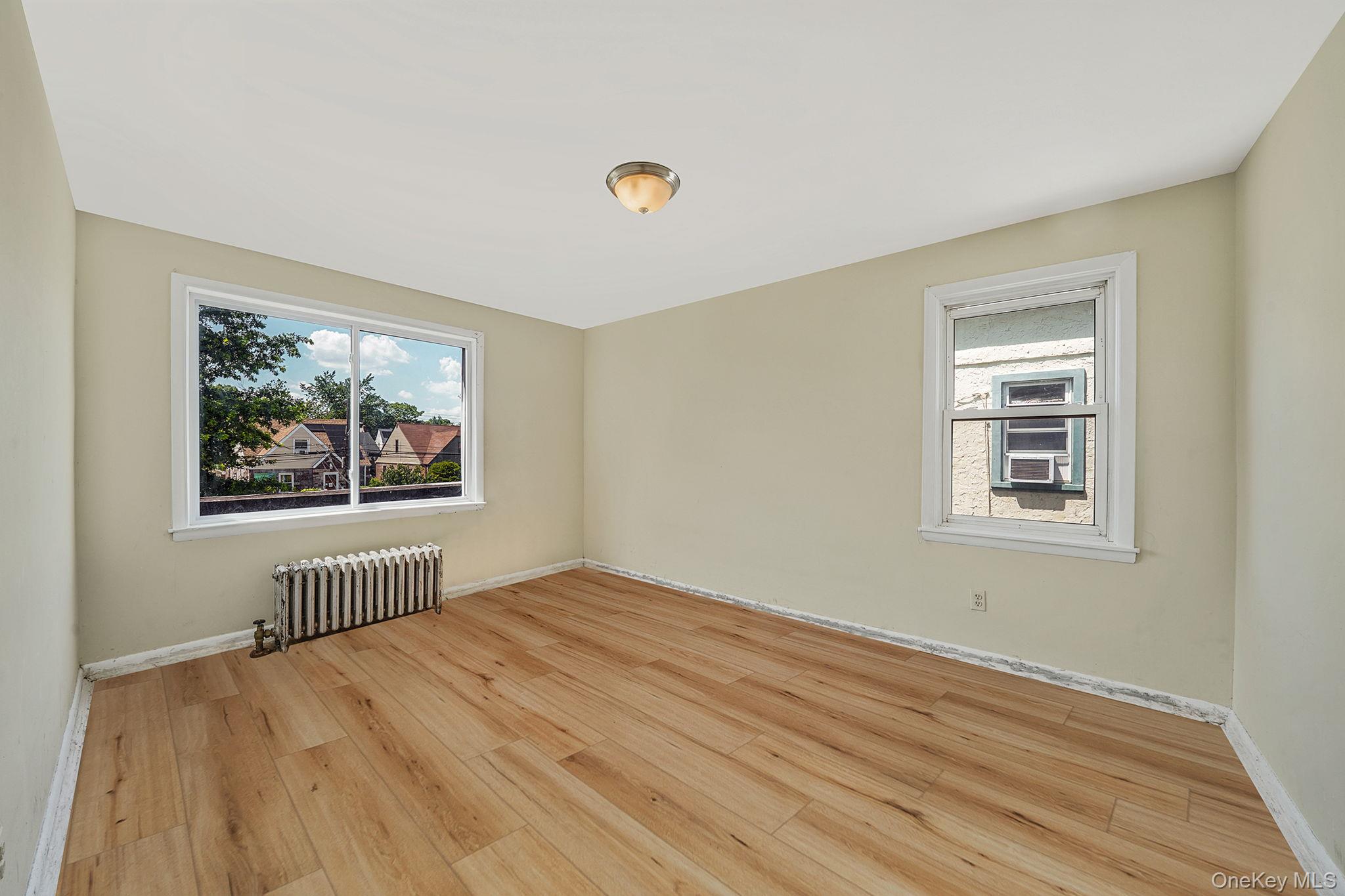 138-41 230th Place Queens, NY 11413 - Photo 12 of 17 a view of empty room with window and wooden floor