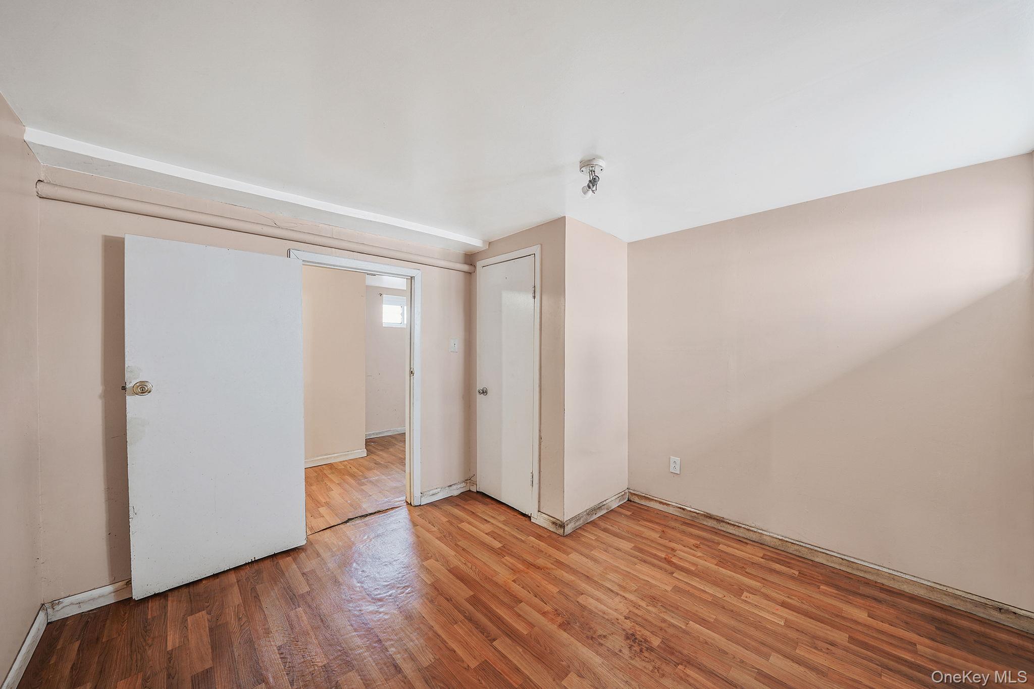 138-41 230th Place Queens, NY 11413 - Photo 15 of 17 a view of an empty room with wooden floor