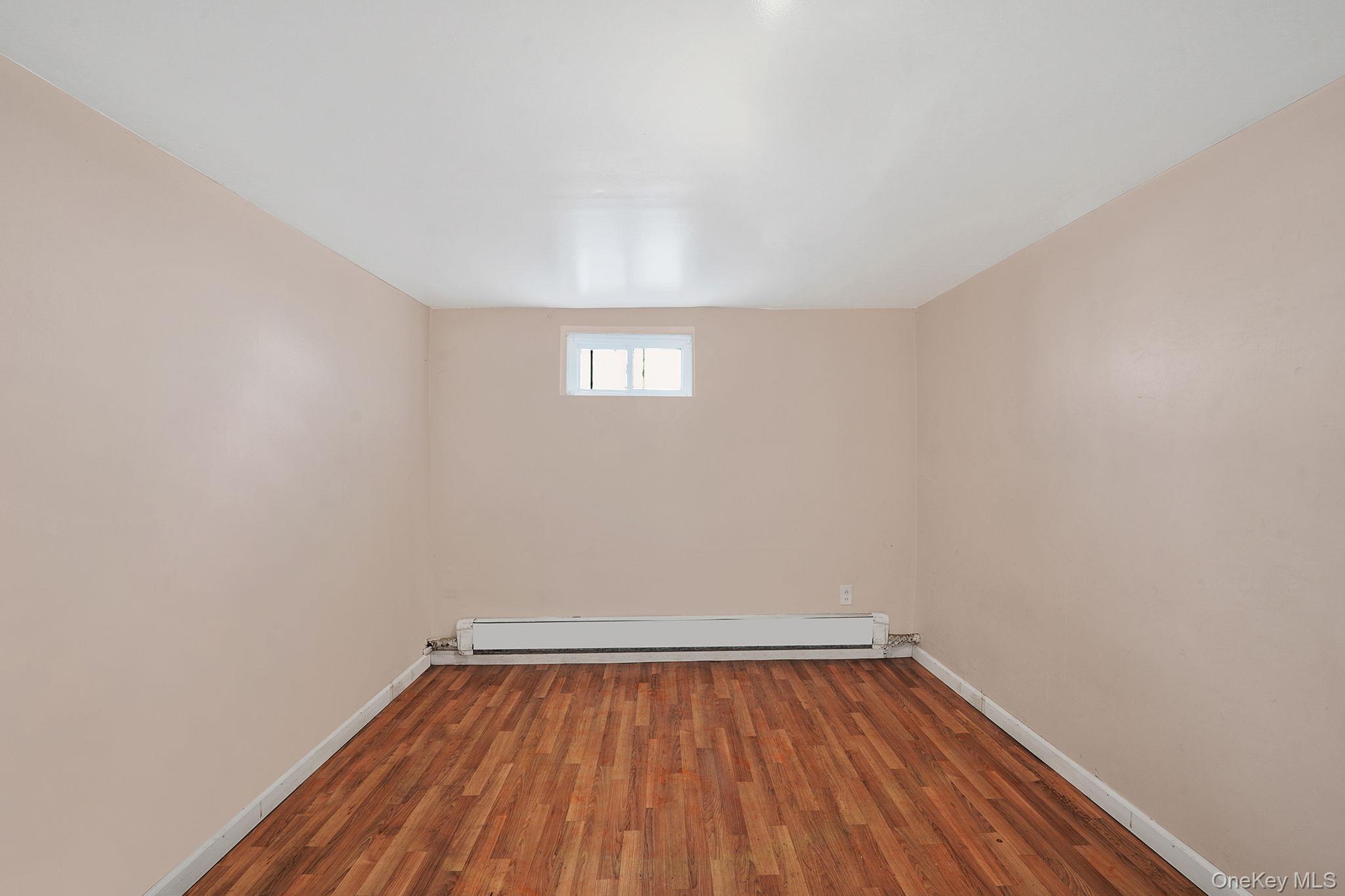 138-41 230th Place Queens, NY 11413 - Photo 16 of 17 a view of an empty room with wooden floor