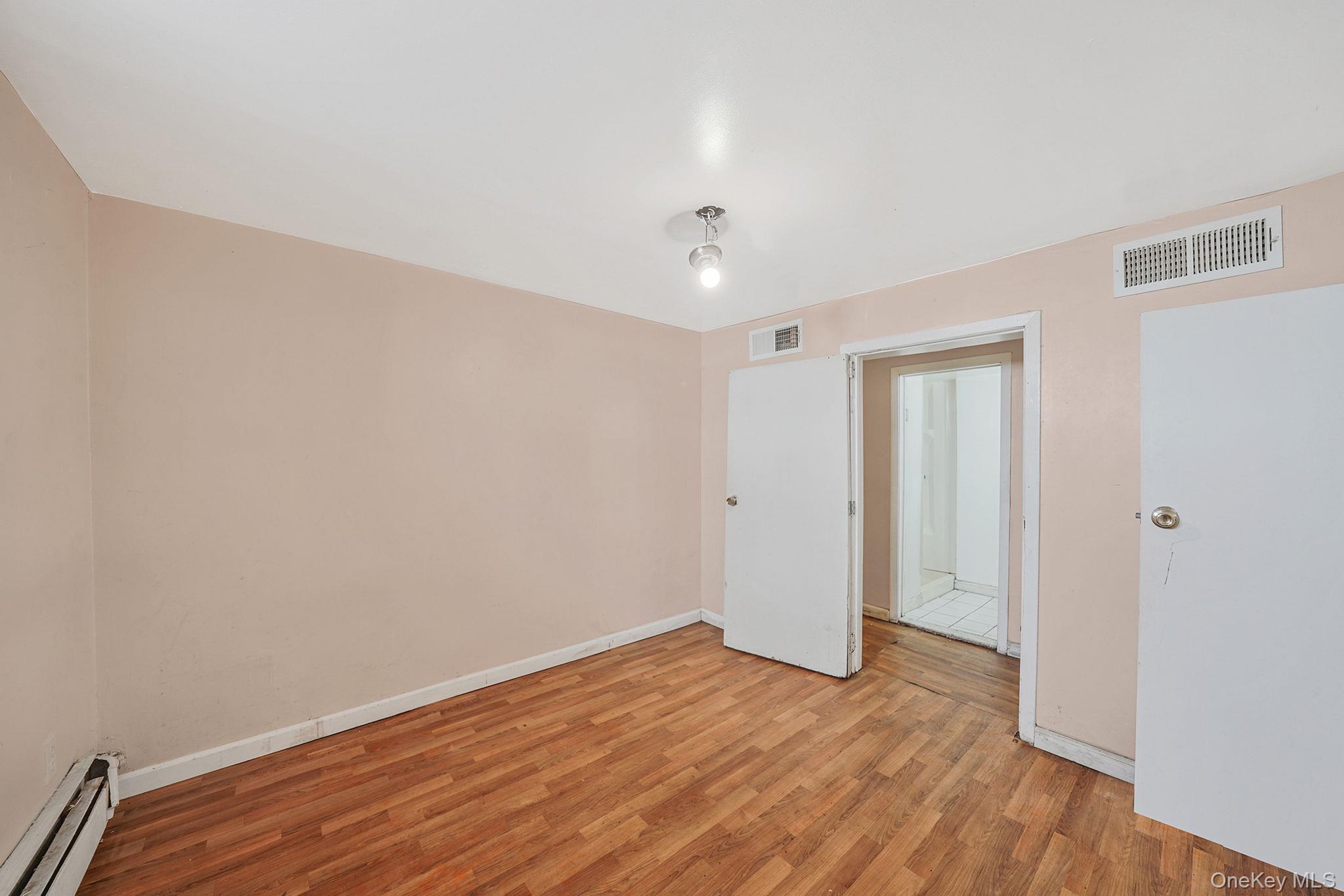 138-41 230th Place Queens, NY 11413 - Photo 17 of 17 a view of an empty room with wooden floor