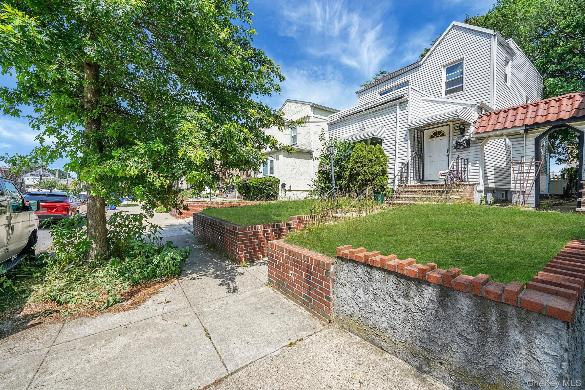 138-41 230th Place Queens, NY 11413 - Photo 2 of 17 a view of a white house with a yard table and chairs