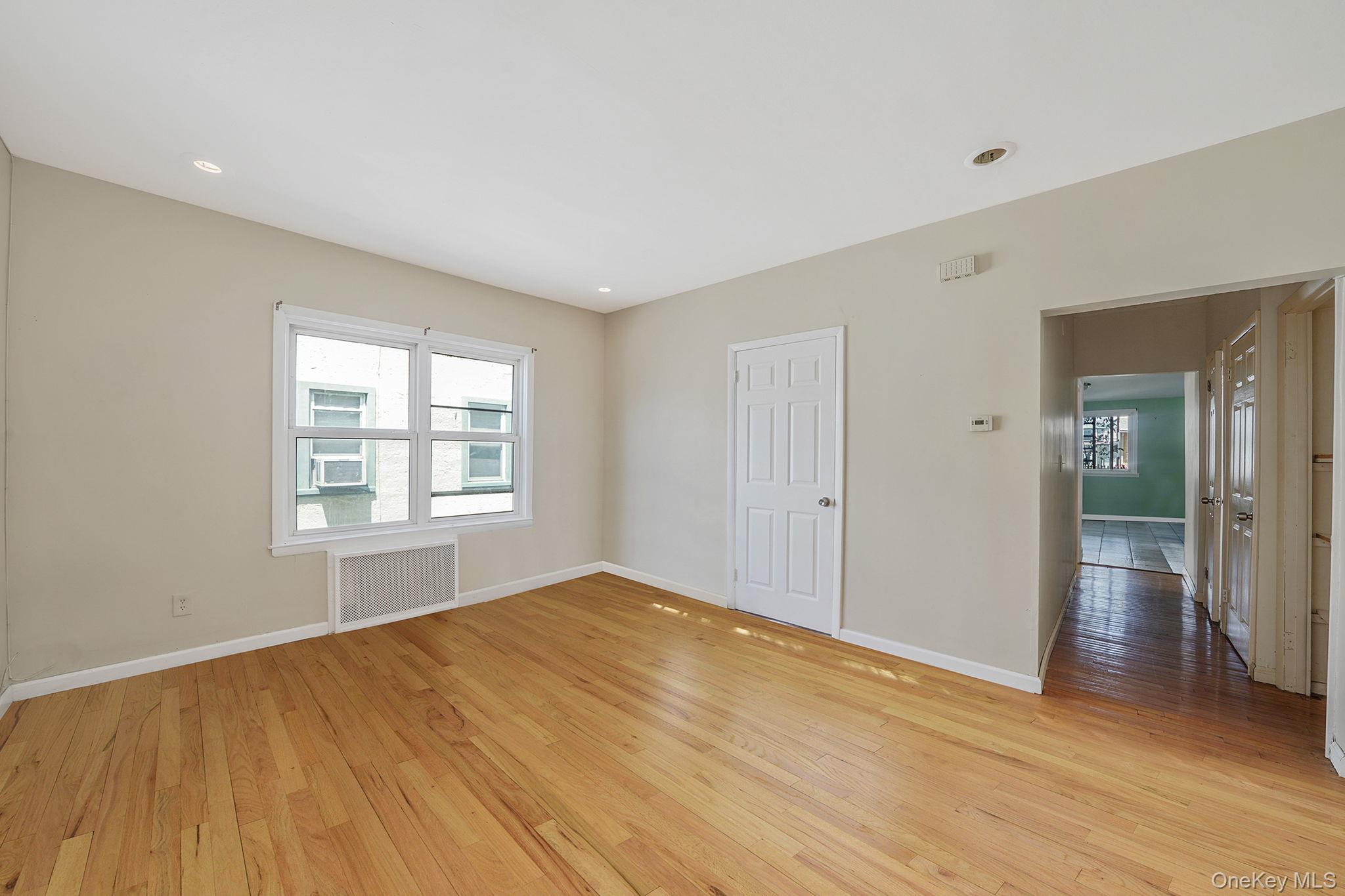 138-41 230th Place Queens, NY 11413 - Photo 6 of 17 a view of empty room with wooden floor and fan
